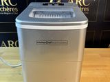 a close up of a small ice maker on a wooden table