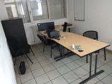 une pièce avec une table, deux chaises et un ordinateur portable posé dessus