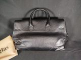 an image of a black leather handbag with a brown paper bag
