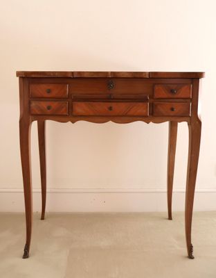 a small wooden table with two drawers on it