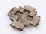 croix plaquée argent sur une surface blanche, sur fond blanc