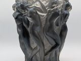un vase noir orné d'un motif sur un fond blanc