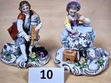 deux figurines représentant un garçon et une fille assis sur un rocher