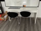deux chaises noires placées devant un tableau blanc