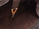 the inside of a brown leather bag with a gold y on it