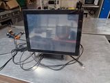 a computer monitor sitting on a table in a kitchen