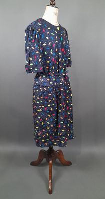 une robe bleue parsemée de paillettes colorées, posée sur un présentoir pour mannequin