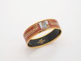 a close up of a gold ring with a red and white design