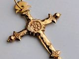 une croix en or surmontée d'une couronne, posée sur une table