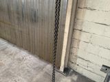 a chain hanging from the side of a building next to a ladder