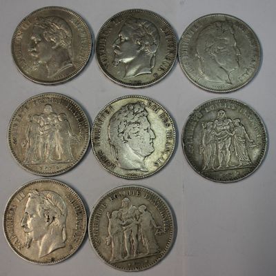 six silver coins of different sizes and shapes on a white surface