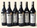 six bouteilles de vin sont alignées sur une table