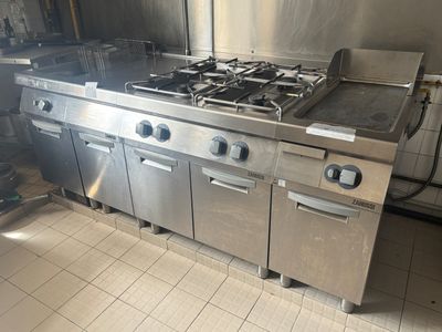 une grande cuisinière en inox au milieu de la cuisine