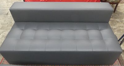 grey leather sofa and ottoman for sale at a furniture store