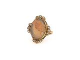 un gros plan sur une bague en or sur laquelle figure le portrait d'une femme