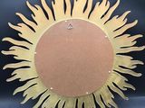 a large metal sun clock on display on a blue background