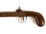 un vieux fusil exposé sur une surface blanche