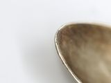 a spoon that is sitting on a white surface