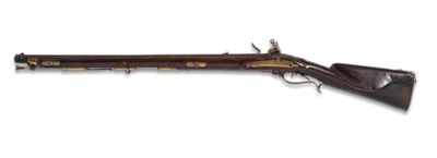 un vieux fusil avec un canon en bois et des garnitures en laiton
