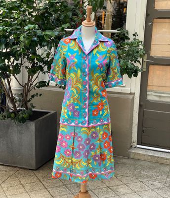 une robe posée sur un mannequin devant une plante