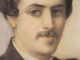 portrait of a man in a suit and bow tie in front of a white wall