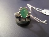 une bague sertie d'une pierre verte, posée sur une table