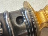 a close up of a metal object with a gold handle