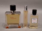 two bottles of perfume sitting next to each other on a white surface