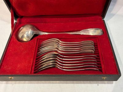 silverware in a red case on a table with a white table cloth