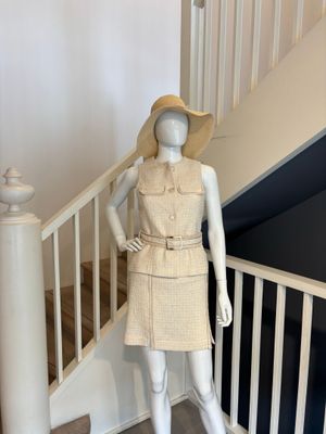 un mannequin portant une robe et un chapeau, sur les escaliers
