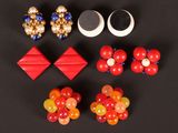 several pairs of earrings are arranged on a black surface