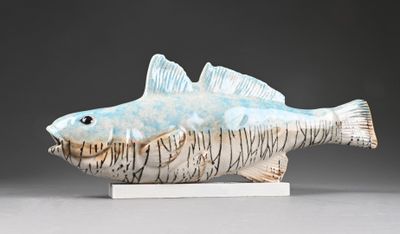 ceramic sculpture of a fish on a stand on a gray surface