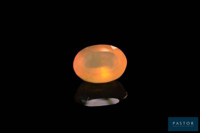 a yellow oplite gems on a black surface