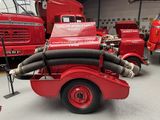 un camion de pompiers rouge muni d'une lance à eau à l'arrière
