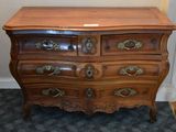 a wooden chest of drawers with brass hardware on it