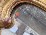 a close up of a mirror reflecting a building in the background