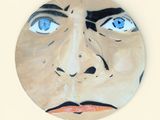 une assiette sur laquelle est représenté un homme aux yeux bleus