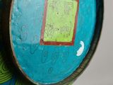 a blue vase with a green and yellow design on it