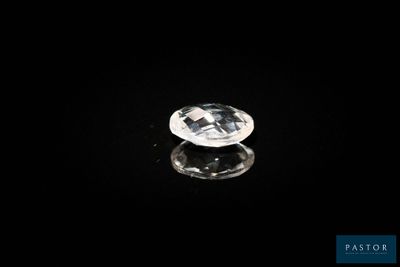 un diamant blanc sur une surface noire, avec un reflet