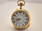 une montre de poche en or sur une surface blanche