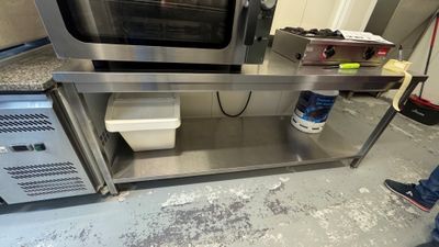 une personne debout devant un four dans une cuisine