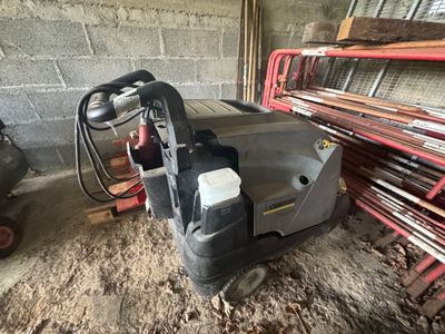 une machine posée par terre à côté d'un tas de bois