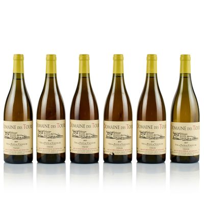 six bottles of wine are lined up on a white surface