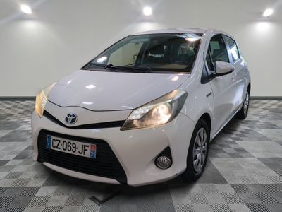 La Toyota Yaris est garée dans une salle blanche dont le sol est à damier.