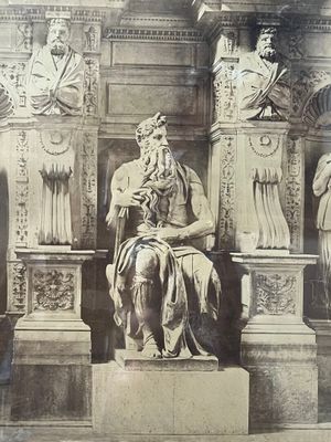 une vieille photo représentant la statue d'un homme assis sur un trône