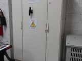 a metal cabinet with a sign on it in a room