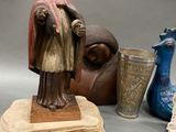 a statue of a man standing next to a vase and a vase