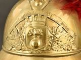 a gold helmet with a red feather on it