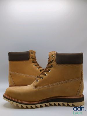 a close up of a pair of yellow boots on a white background