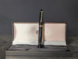 the black pen is sitting in the box on the table